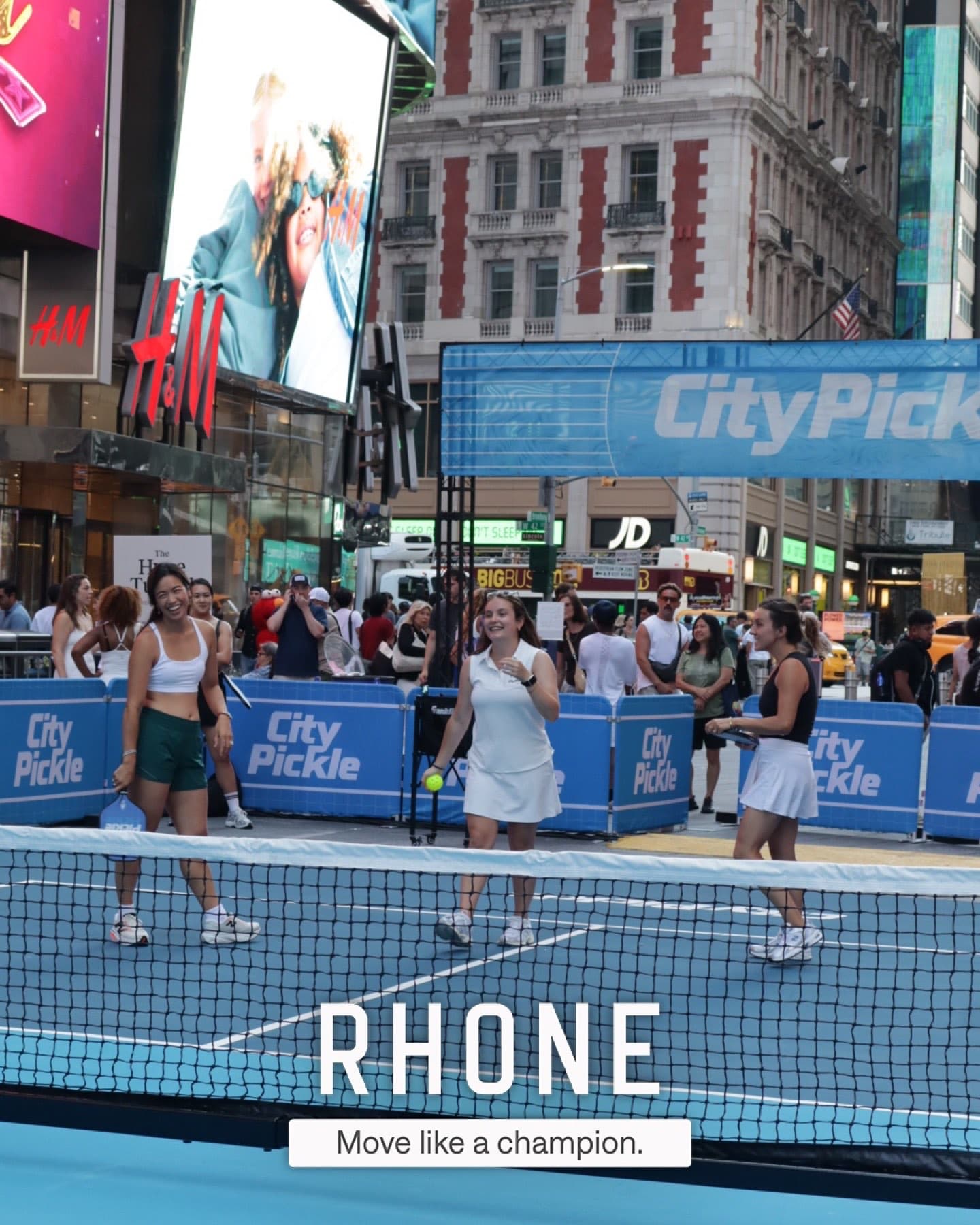 A guest mid-rally on the City Pickle court beneath the Rhone Hype Tunnel signage in Times Square.