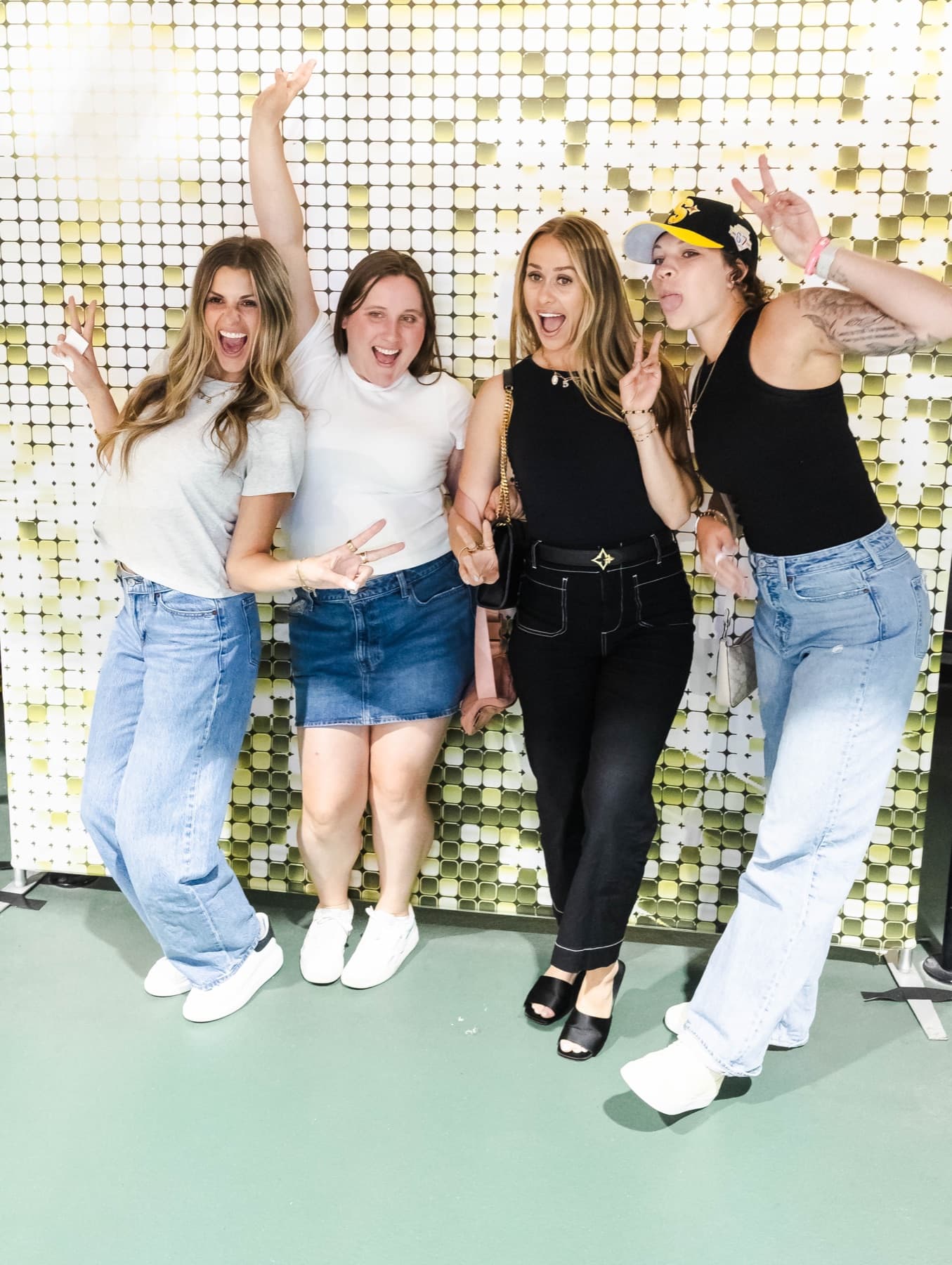 A group of fans celebrating in front of the gold shimmer wall.