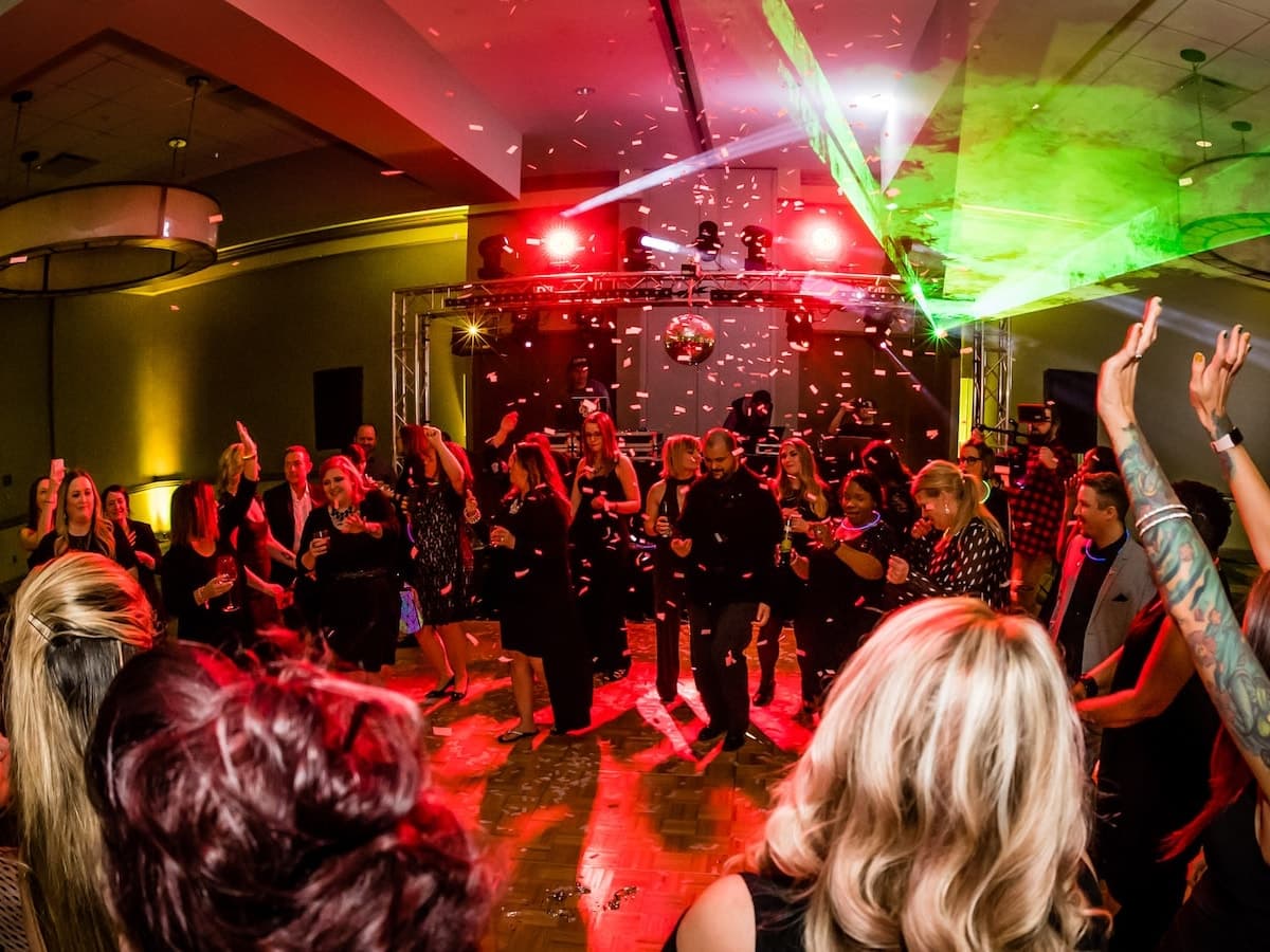 Confetti falling over a full corporate dancefloor mid-celebration.