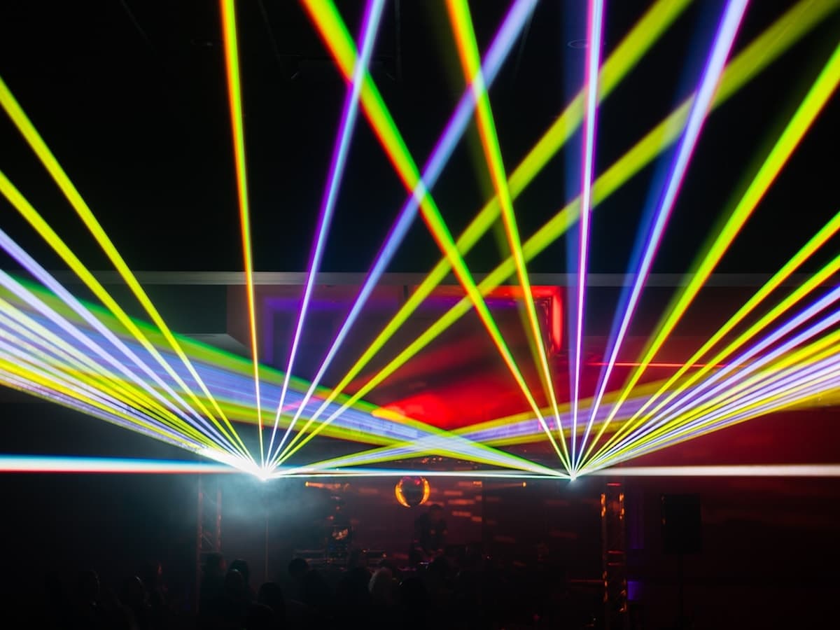 Multicolor laser array fanning over a packed event floor, programmed by DigiTron show control.